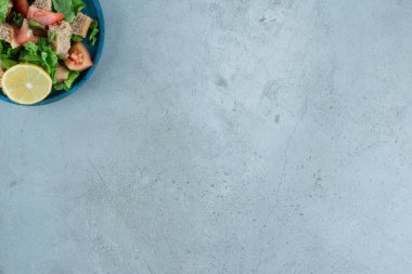 Dilimlenmiş domates, ekmek, limon ve mavi tabakta yeşiller. Yüksek kalite fotoğraf