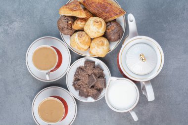 Kahvaltının yanında kahve ve gri arka planda ev yapımı lezzetli tatlılar..