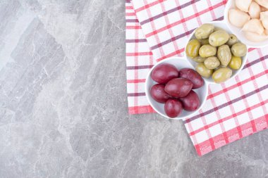 Bir kase erik turşusu, zeytin ve sarımsak masa örtüsü. Yüksek kalite fotoğraf