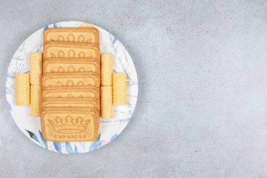 Bisküviler mermer arka planda bir tabağa dizilmiş. Yüksek kalite fotoğraf