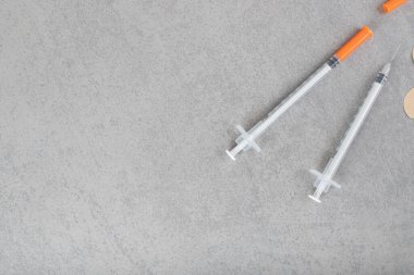 Gri arka planda üç alçılı iki boş şırınga. Yüksek kalite fotoğraf