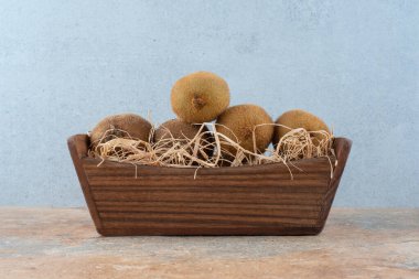 Mermer zemin üzerinde ahşap bir sepet taze kivi. Yüksek kalite fotoğraf