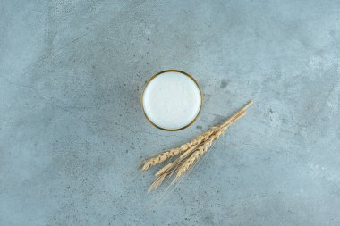 Gri arka planda bir bardak lezzetli bira ve buğday. Yüksek kalite fotoğraf