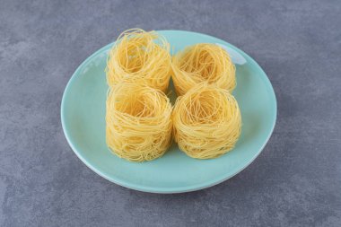 Mavi tabakta çiğ makarna yuvaları. Yüksek kalite fotoğraf