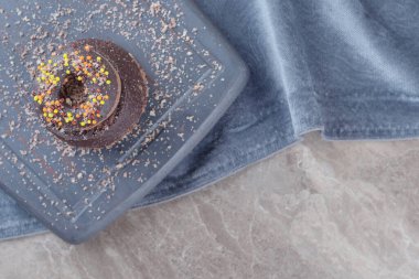 Mermer zemin üzerinde küçük bir çikolatalı pasta üzerine çörek. Yüksek kalite fotoğraf