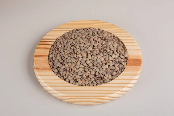 Green lentil beans on a wooden platter. High quality photo