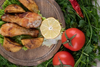 Kızarmış tavuk budu, et ve sebzelerden oluşan ahşap bir tahta. Yüksek kalite fotoğraf