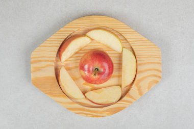 Ahşap tabakta tam ve kırmızı elma dilimleri. Yüksek kalite fotoğraf