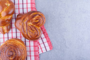 Mermer arka planda bir havlu üzerine dizilmiş tatlı çörekler. Yüksek kalite fotoğraf
