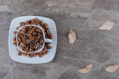 Yapraklar ve mermer arka planda bir fincan tohum. Yüksek kalite fotoğraf