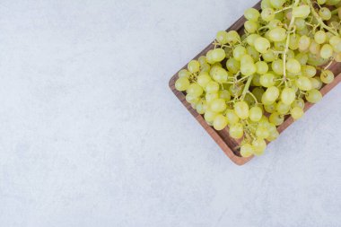 Beyaz arka planda tatlı üzümlerle dolu tahta bir tahta. Yüksek kalite fotoğraf