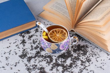 Meyve dilimleri ve kitaplarla bir fincan siyah çay. Yüksek kalite fotoğraf