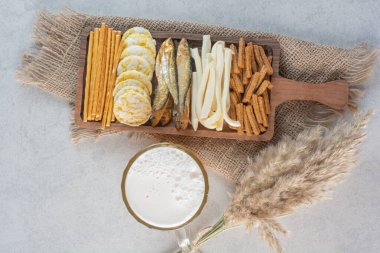 Bira ve bezelyeli lezzetli balık ve peynirle dolu ahşap bir tabak. Yüksek kalite fotoğraf