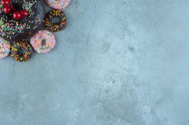Donut aperatifleri mermer arka planda büyük bir donut etrafında. Yüksek kalite fotoğraf