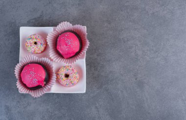Pembe jöleli çikolata topları ve beyaz tabakta donutlar. Yüksek kalite fotoğraf
