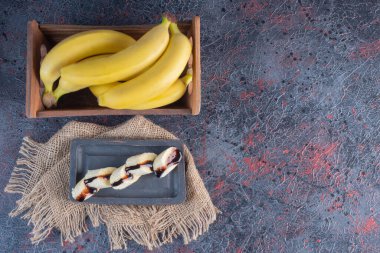 Çikolatalı dilimlenmiş muz ve ahşap kutuda muz. Yüksek kalite fotoğraf