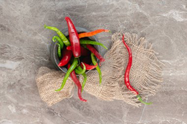 Kırmızı ve yeşil biberler mermer arka planda metal bir sürahi içinde. Yüksek kalite fotoğraf