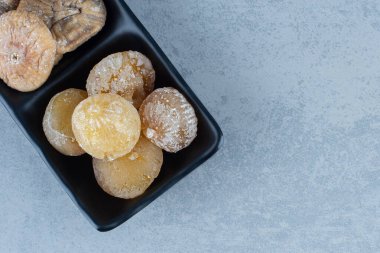 Mermer arka planda, kasede iki çeşit kurutulmuş meyve var. Yüksek kalite fotoğraf