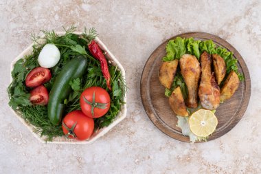 Kızarmış tavuk budu, et ve sebzelerden oluşan ahşap bir tahta. Yüksek kalite fotoğraf