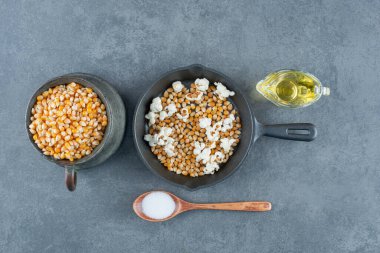 Patlamış mısır pişirme malzemeleri ve malzemeler mermer arka planda sergileniyor. Yüksek kalite fotoğraf