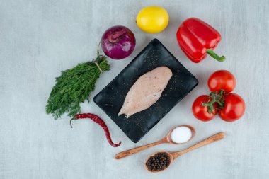 Tavuk göğsü, baharatlar ve gri yüzeyde çeşitli sebzeler. Yüksek kalite fotoğraf