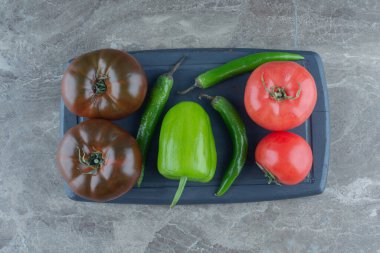 Tepside domates ve biber var, mermer arka planda. Yüksek kalite fotoğraf