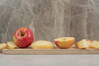 Tahtada tam ve kırmızı elma dilimleri var. Yüksek kalite fotoğraf