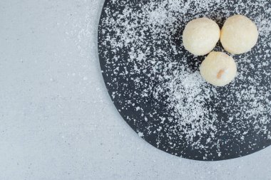 Pudra şekerli yuvarlak hamur işi koyu bir kesim tahtası. Yüksek kalite fotoğraf