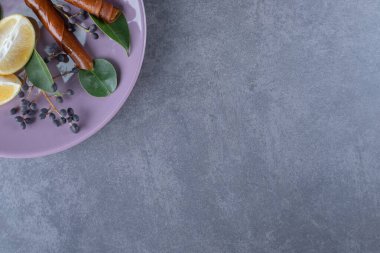 Gri arka planda mor tabakta taze limon dilimleri. Yüksek kalite fotoğraf