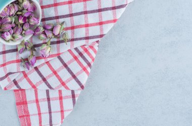 Havlunun üzerindeki kasede, mermer zeminde kurumuş gül çiçeği var. Yüksek kalite fotoğraf