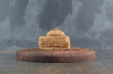 Tahta zeminde kurabiye ile kaplı küçük bir dilim pasta. Yüksek kalite fotoğraf