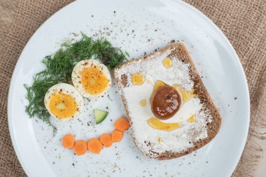 Çuval bezinde haşlanmış yumurta ve tost ile beyaz bir tabak. Yüksek kalite fotoğraf