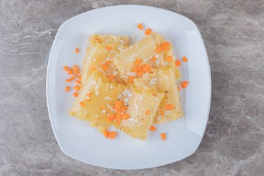 Lazanya çarşafları ve rendelenmiş havuç tabakta, mermer arka planda. Yüksek kalite fotoğraf