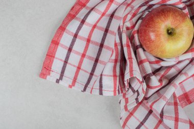 Çizgili masa örtüsü üzerinde kırmızı bir elma. Yüksek kalite fotoğraf