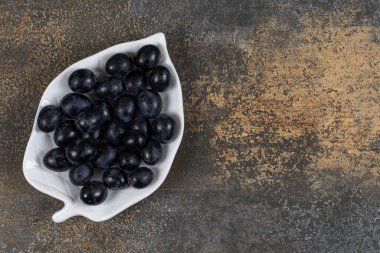 Yaprak şeklinde tabakta bir demet siyah üzüm. Yüksek kalite fotoğraf