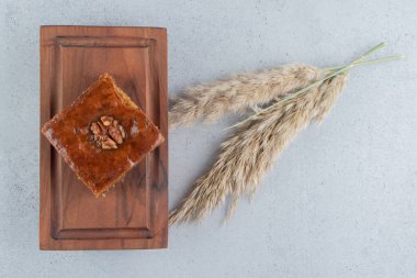 Bakhlava, mermer arka plandaki tüy çimlerinin yanında küçük bir tahtanın üzerinde. Yüksek kalite fotoğraf