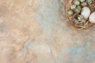 Mermer arka planda bıldırcın yumurtaları olan hasır sepet. Yüksek kalite fotoğraf
