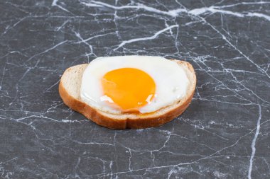 Dilimlenmiş ekmeğin üzerinde yumurta, mermer arka planda. Yüksek kalite fotoğraf