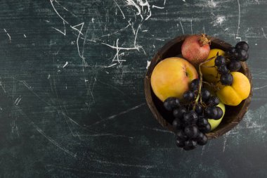 Şeftali ve üzümler kara tahtada tahta bir kasede. Yüksek kalite fotoğraf