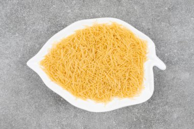 Beyaz tabakta pişmemiş makarna yığını. Yüksek kalite fotoğraf