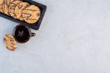 Küçük bir tepside kurabiyeler mermer arka planda bir fincan çayın yanında. Yüksek kalite fotoğraf