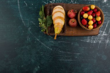 Kiraz tabağı, üzerinde nar ve ahşap bir tepside armut. Yüksek kalite fotoğraf
