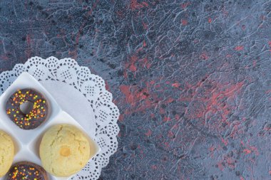 Aperatif büyüklüğünde çörekler ve kurabiyeler soyut arka planda servis tabağında servis ediliyor. Yüksek kalite fotoğraf