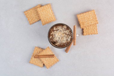 Kraker ve tarçın çubuklu bir fincan lezzetli içecek. Yüksek kalite fotoğraf