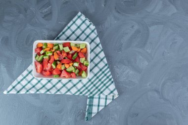 Çoban salatasının altında katlanmış masa örtüsü mermer zemin üzerinde havuç dilimleriyle karıştırılmış. Yüksek kalite fotoğraf