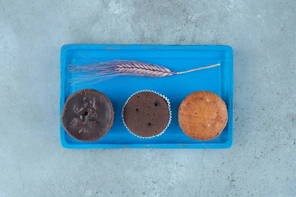 Surtido Cupcakes Tallo Trigo Morado Una Bandeja Azul Sobre Fondo —  Fotos de Stock