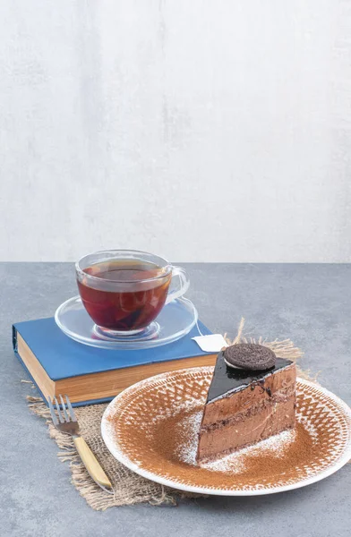 A piece of cake with aroma tea and book. High quality photo