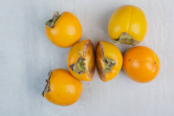 Bunch of tasty persimmons on stone background. High quality photo