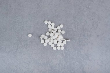 Gri arka planda bir sürü beyaz daire hapı var. Yüksek kalite fotoğraf