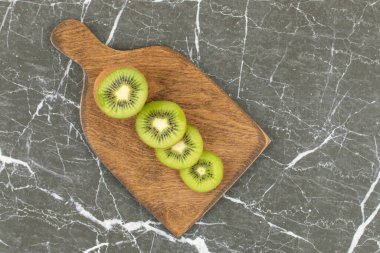 Tahta kesme tahtasının üzerinde yarısı kesilmiş ve dilimlenmiş kivi. Yüksek kalite fotoğraf